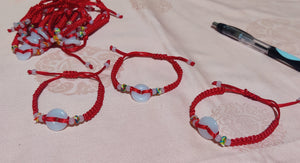 Bracelet à ficelle rouge et pierre blanche